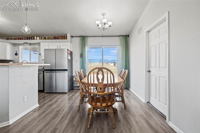 dining space featuring hardwood / wood-style flooring, a chandelier, and a wealth of natural light