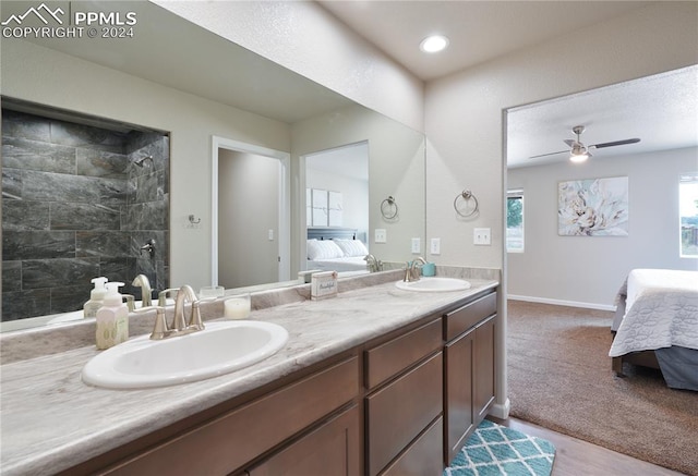 bathroom with ceiling fan, vanity, and a tile shower