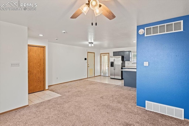 unfurnished living room featuring ceiling fan and light colored carpet