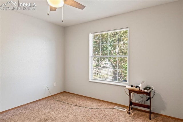 carpeted spare room featuring ceiling fan and a healthy amount of sunlight