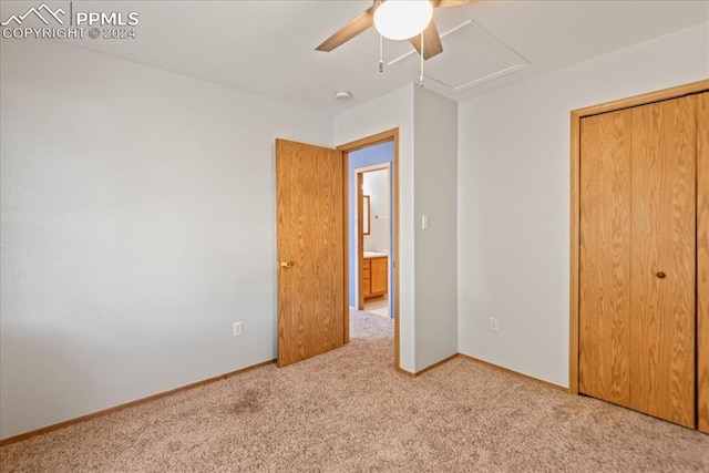 unfurnished bedroom with a closet, ceiling fan, and light colored carpet