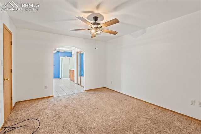 carpeted spare room with ceiling fan