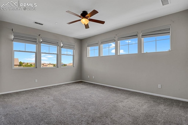 unfurnished room featuring carpet floors, ceiling fan, and a wealth of natural light