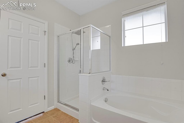 bathroom with tile patterned flooring and separate shower and tub