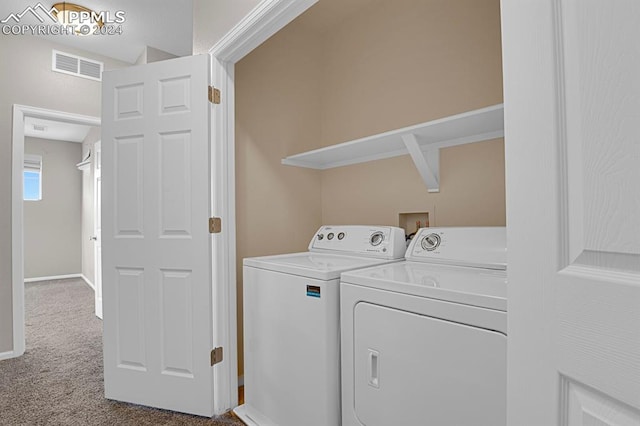 clothes washing area with independent washer and dryer and carpet