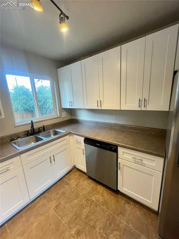 kitchen with stainless steel appliances, white cabinetry, and sink