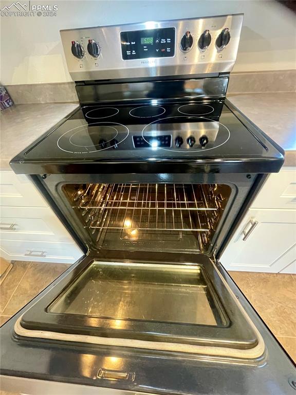 details featuring stainless steel electric range and white cabinets