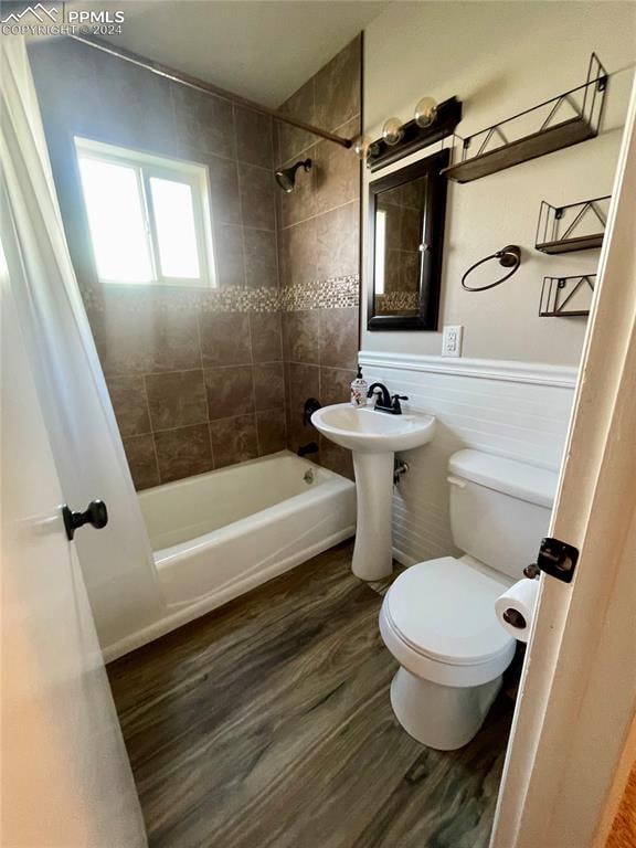 bathroom featuring wood-type flooring, toilet, and shower / tub combo