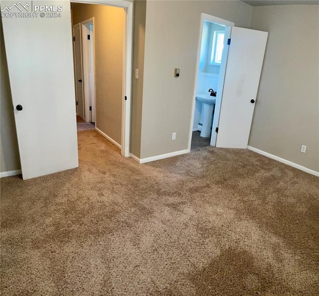 unfurnished bedroom with carpet flooring, sink, and ensuite bathroom