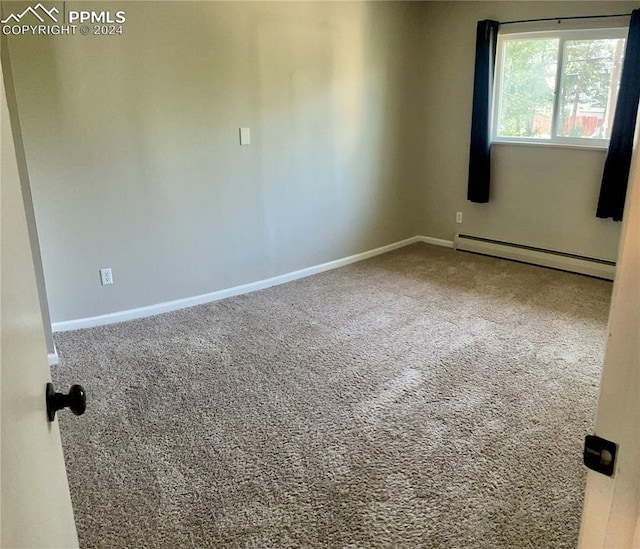 empty room with baseboard heating and carpet flooring