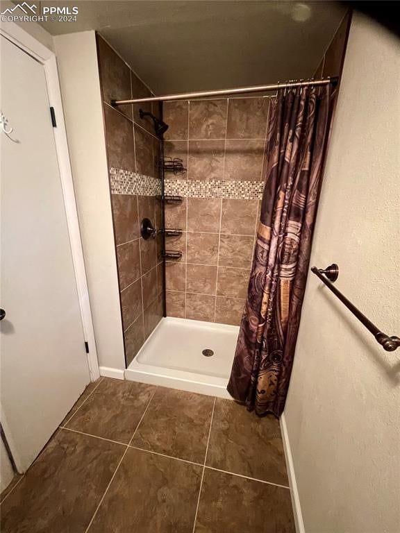 bathroom with a shower with shower curtain and tile patterned floors