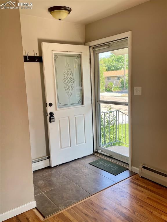 entrance foyer with a baseboard radiator and dark wood-type flooring