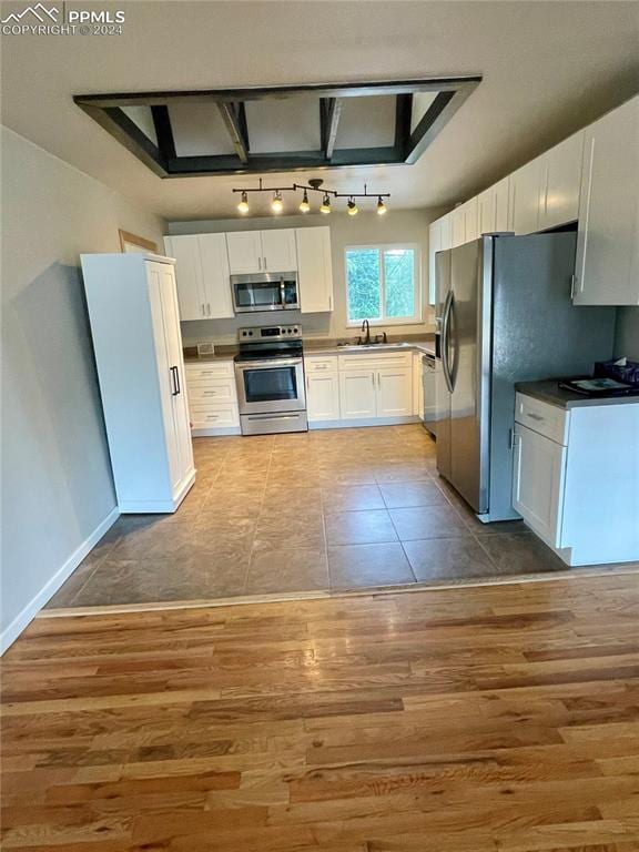 kitchen featuring light hardwood / wood-style flooring, white cabinets, appliances with stainless steel finishes, and sink