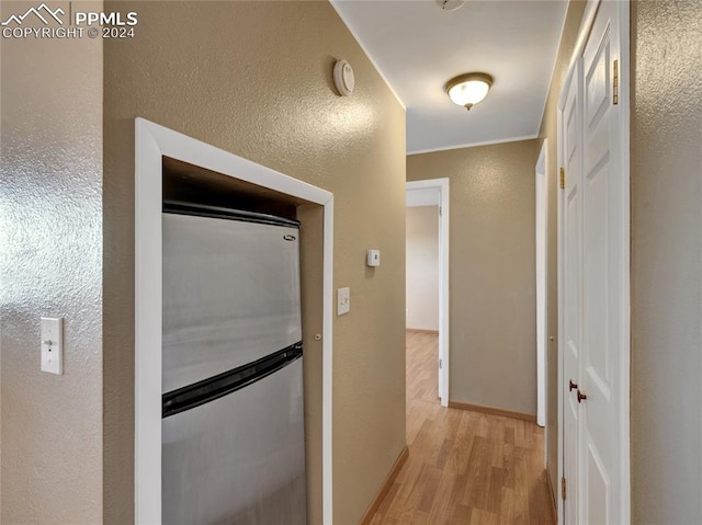 hall with light hardwood / wood-style flooring and ornamental molding