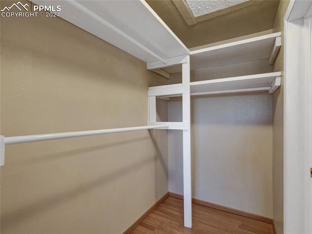 walk in closet featuring a skylight and hardwood / wood-style flooring