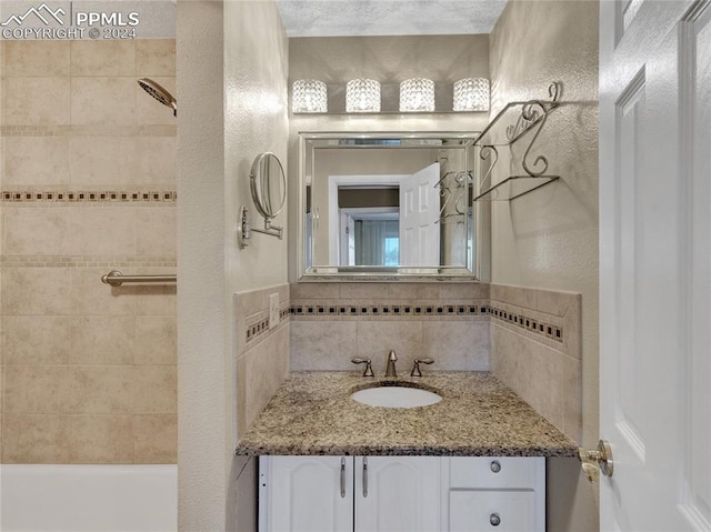 bathroom featuring tiled shower / bath combo and vanity