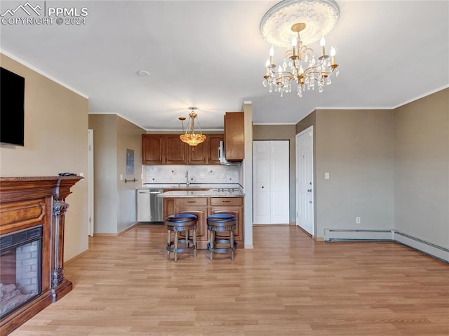 kitchen with light wood-type flooring, stainless steel dishwasher, and decorative light fixtures