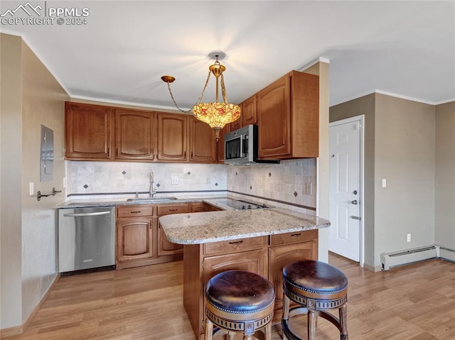 kitchen with hanging light fixtures, sink, a baseboard heating unit, stainless steel appliances, and light hardwood / wood-style floors