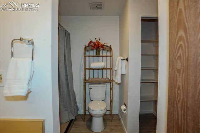 bathroom with toilet, hardwood / wood-style floors, and a shower with shower curtain