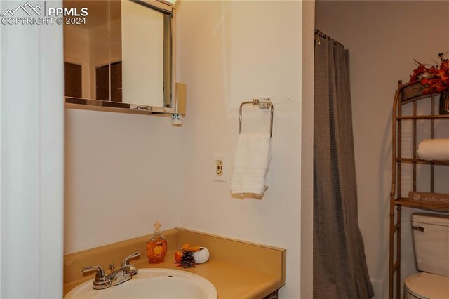 bathroom with a shower with curtain, vanity, and toilet