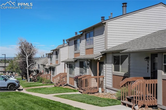 exterior space with a front lawn and a wooden deck