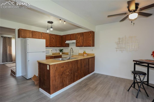 kitchen featuring pendant lighting, white appliances, kitchen peninsula, and light hardwood / wood-style floors