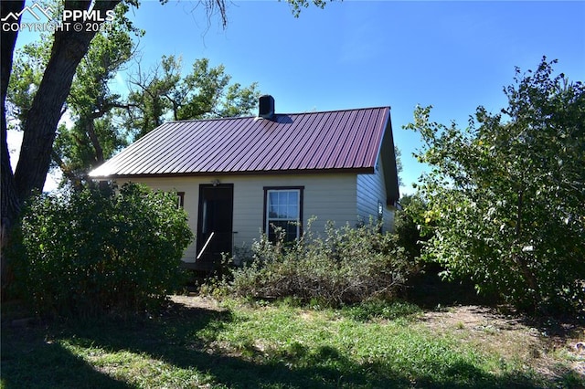 rear view of property with metal roof