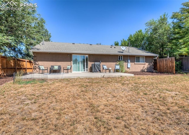 back of house with a patio and a lawn