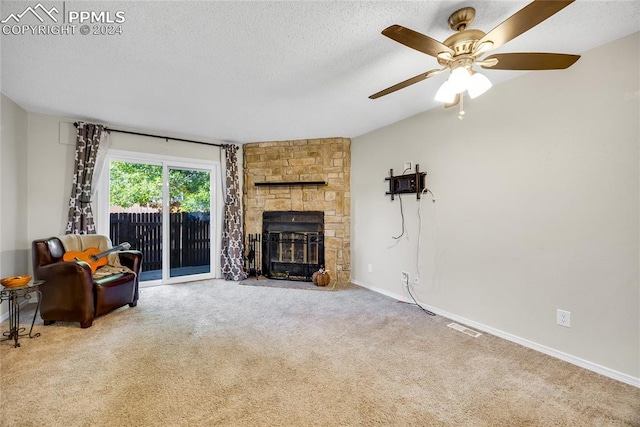 carpeted living room with ceiling fan, a stone fireplace, a textured ceiling, and vaulted ceiling