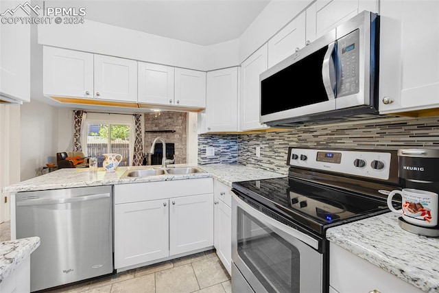 kitchen featuring white cabinets, stainless steel appliances, sink, and kitchen peninsula