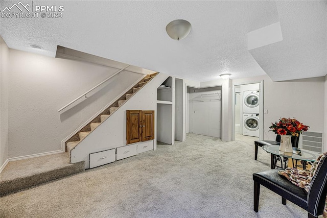 interior space with carpet floors, a textured ceiling, and stacked washer / drying machine