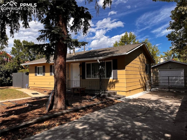 single story home featuring an outbuilding and a garage