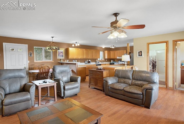 living room featuring light wood-type flooring, sink, and ceiling fan