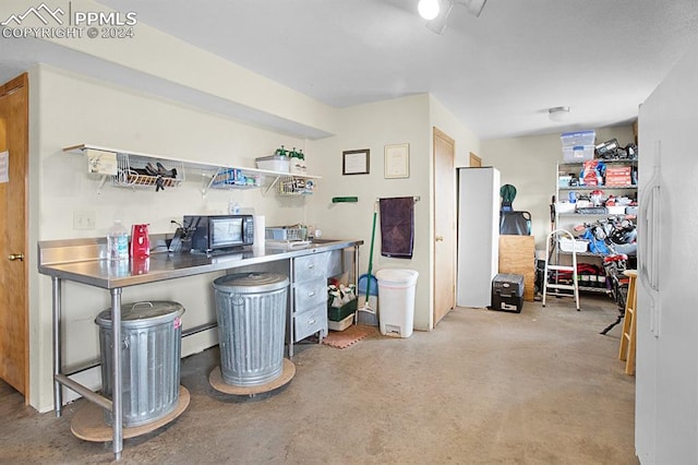 kitchen with a kitchen breakfast bar, a baseboard heating unit, kitchen peninsula, and stainless steel counters