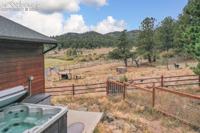 view of yard with a mountain view, a hot tub, and a rural view