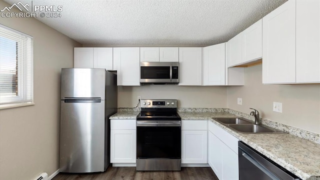 kitchen featuring white cabinets, a textured ceiling, stainless steel appliances, and sink