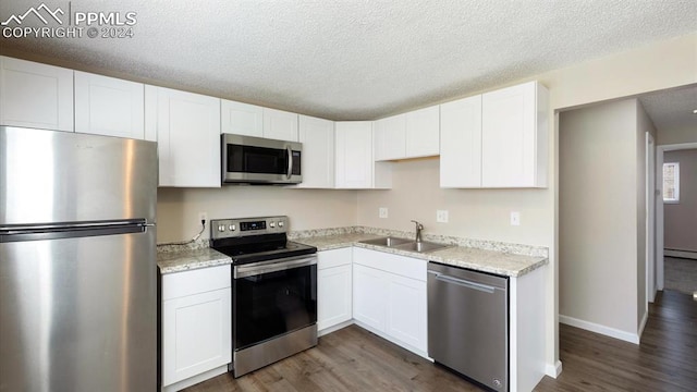 kitchen featuring white cabinets, appliances with stainless steel finishes, dark wood-type flooring, and sink