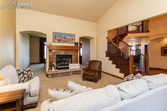 carpeted living room with high vaulted ceiling and a fireplace