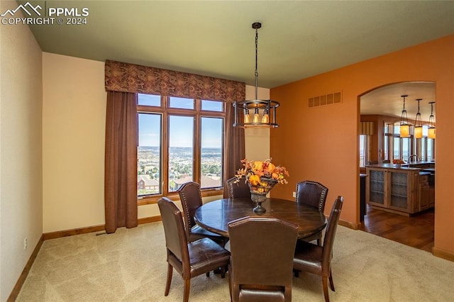 carpeted dining area featuring a notable chandelier