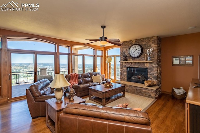 living room featuring a fireplace, a water view, ceiling fan, and hardwood / wood-style flooring