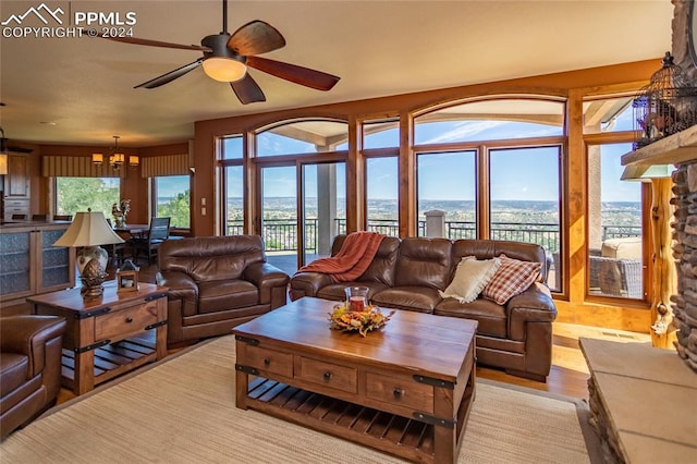 living room featuring light wood-type flooring and ceiling fan with notable chandelier