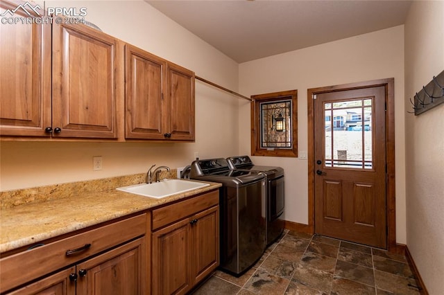 laundry room featuring separate washer and dryer, sink, and cabinets