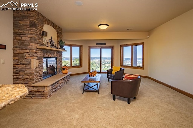 living room featuring carpet and a stone fireplace