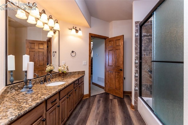 bathroom featuring vanity, hardwood / wood-style flooring, and enclosed tub / shower combo