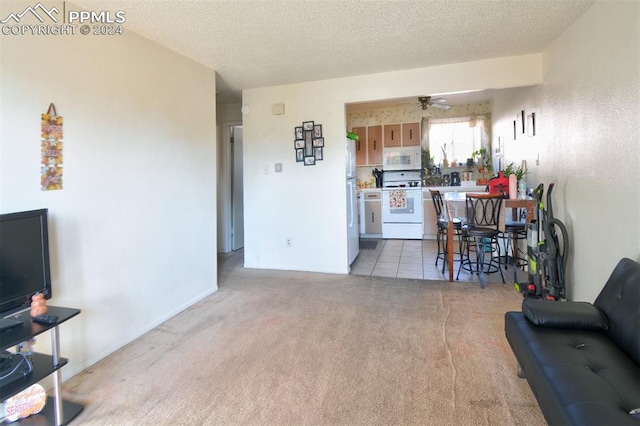 carpeted living room with a textured ceiling and ceiling fan