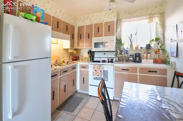 kitchen featuring white appliances, sink, light tile patterned floors, and ceiling fan