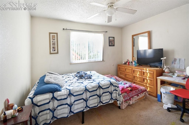 bedroom with ceiling fan, carpet flooring, and a textured ceiling