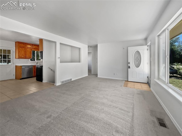 unfurnished living room with light carpet and sink