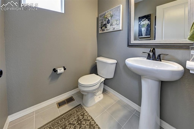 bathroom featuring toilet, sink, and tile patterned floors