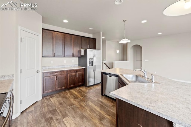 kitchen with pendant lighting, dark brown cabinets, sink, appliances with stainless steel finishes, and dark hardwood / wood-style flooring